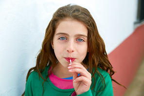 Beautiful blue eyes kid gils eating a lollipop sweet portrait