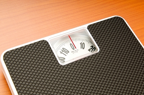 Dieting concept with scales on the wooden floor