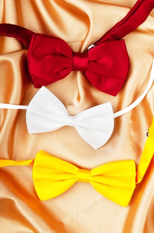 Bow ties on the bright satin background