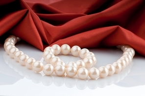 Pearls necklace on satin background