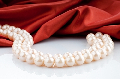 Pearls necklace on satin background