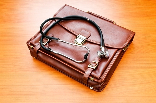 Doctor's case with stethoscope against wooden background