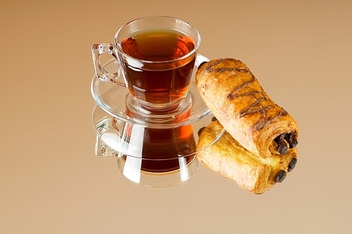 Tea and croissants on the reflective background