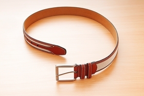 Leather belt on the wooden background