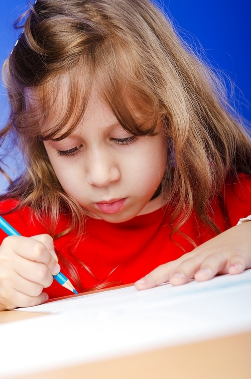 Little girl drawing with pencils