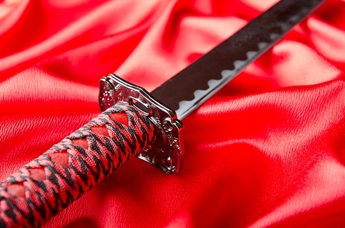 Japanese sword takana on red satin background