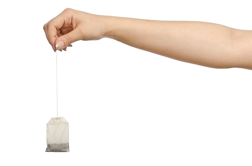 Hand holding teabag on white