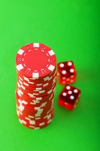 Casino chips and cards against green background