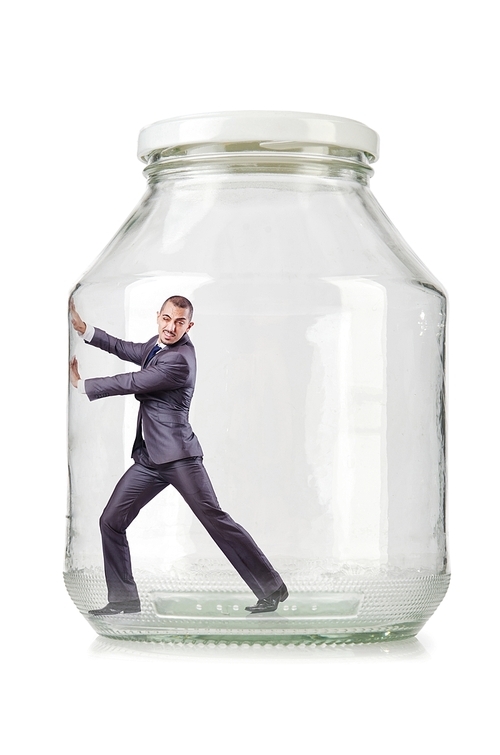 Young businessman in glass jar