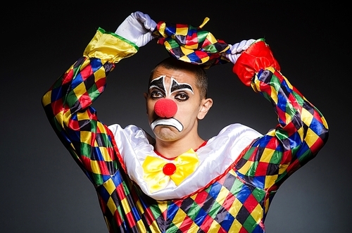 Sad clown against dark background