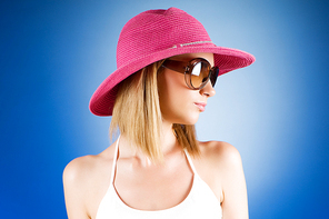 Young girl with beach hat against gradient background