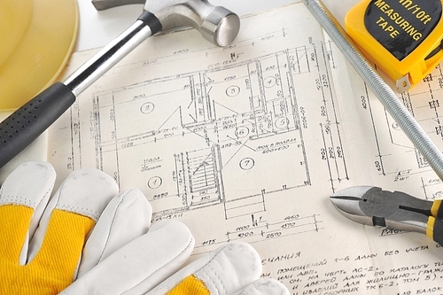 Yellow hardhat|gloves and  hammer on drawings