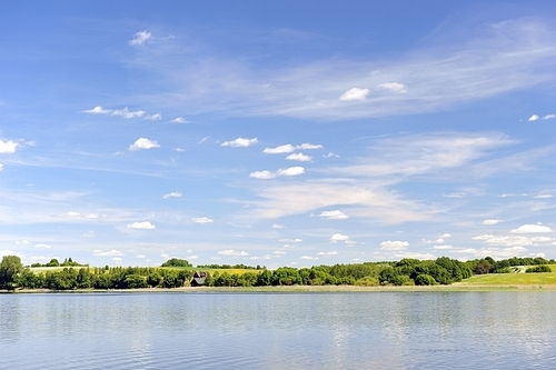 calm water of  lake|woods on other side and  blue sky. landscape
