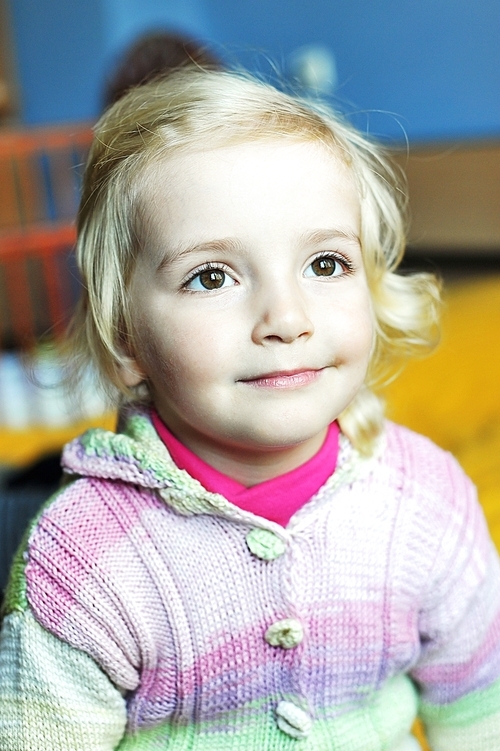 cheerful little girl sits on bed of parents