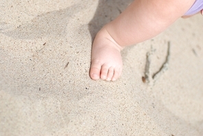 Children's foot on sea sand