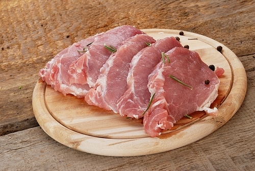 pieces of fresh raw meat on cutting board