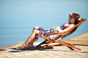 woman sitting in  lounge chair. summer's day on lakeside