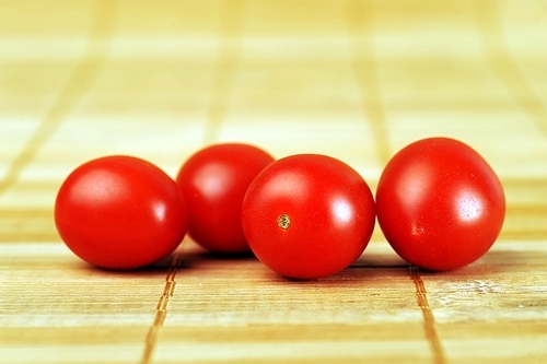 four ripe and juicy cherry tomatoes  on  bamboo napkin