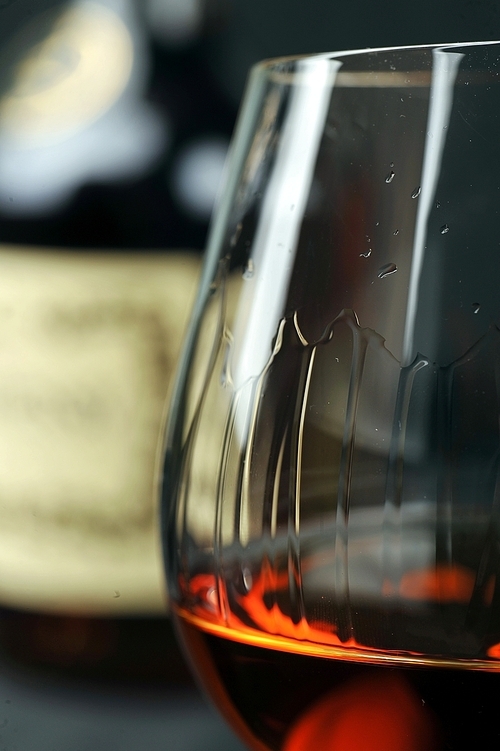 Simple composition of glass and bottle cognac. black background