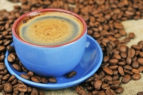 Cup of  coffee and spilled out coffee beans