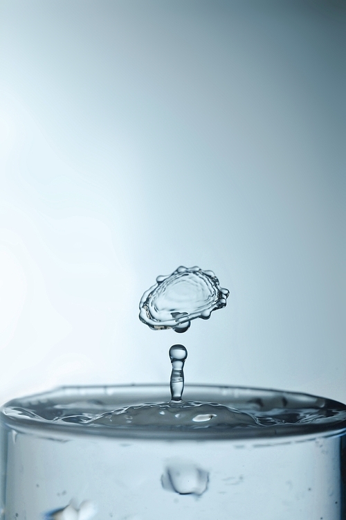 Water drop in rippled liquid closeup