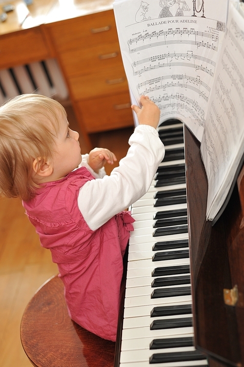 beautiful little girl plays  piano