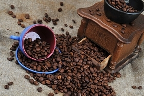 Vintage manual coffee grinder with coffee beans and cup