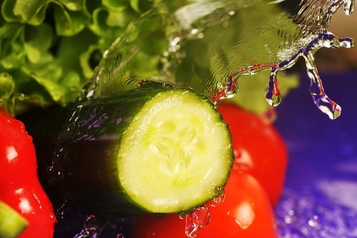 tomatoes|cucumber|salad and splashes on  violet background