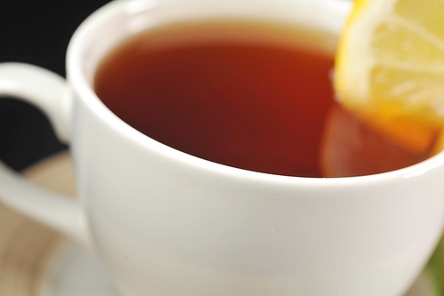 full cup of tea with lemon and   on  black