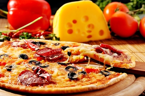 Close up of  pizza with tomatoes|cheese|black olives and  peppers.