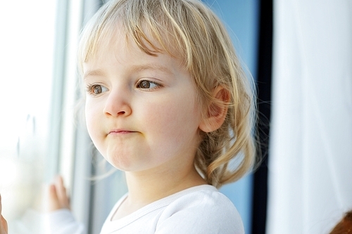 Beautiful  little girl is by window portrait