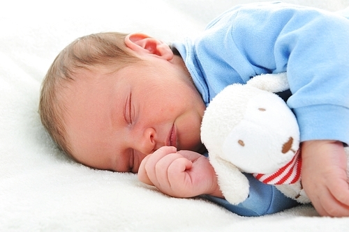 Baby boy in sleeping on bed