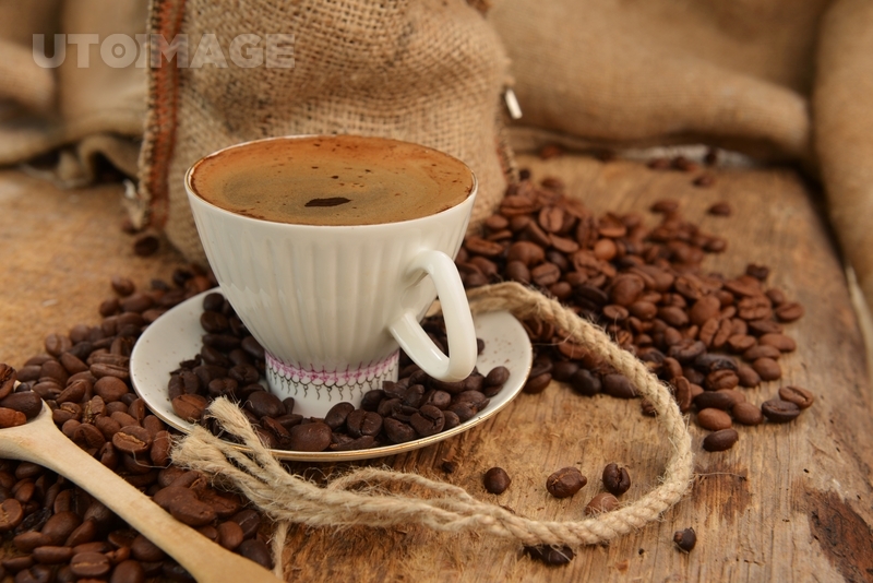 유토이미지 | Roasted coffee beans with cup on jute hessian background