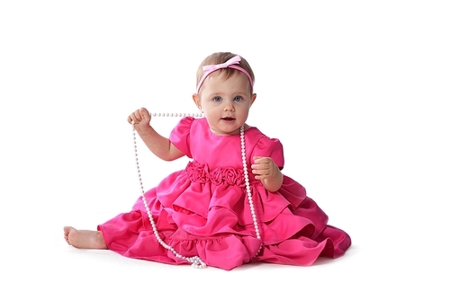 Adorable little baby girl  in  pink dress sitting on floor