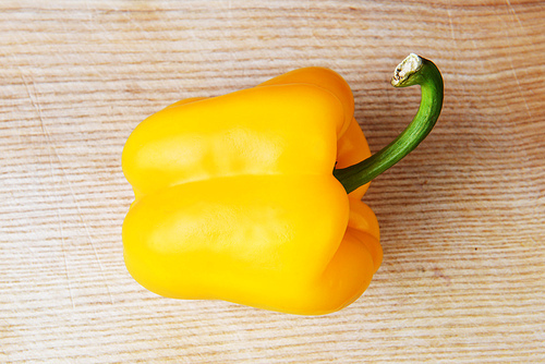 yellow ripe peppers lies on wooden cutting board