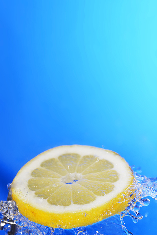 slice of lemon in the water with bubbles|on blue background