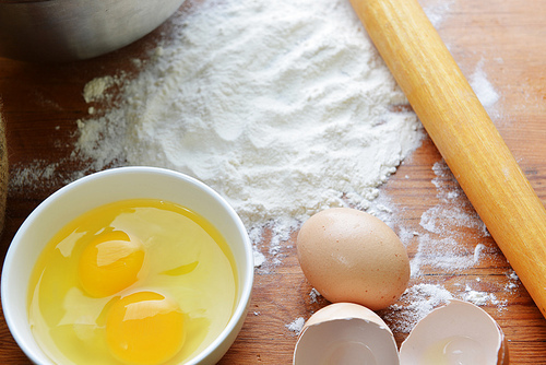 Kitchen rolling pin|eggs  and flour on wooden background