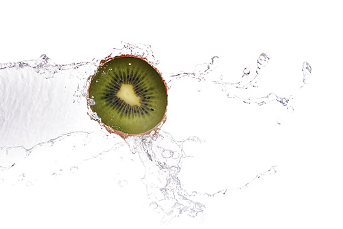 slice of kiwi in  water with bubbles