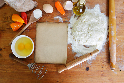 yeast dough|old sheet  and flour on wooden background