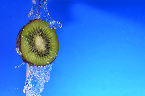 slice of kiwi in the water with bubbles|on blue background