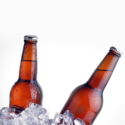 brown bottles of beer chilling on ice