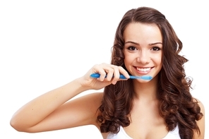 Young woman at home brushing teeth in the morning