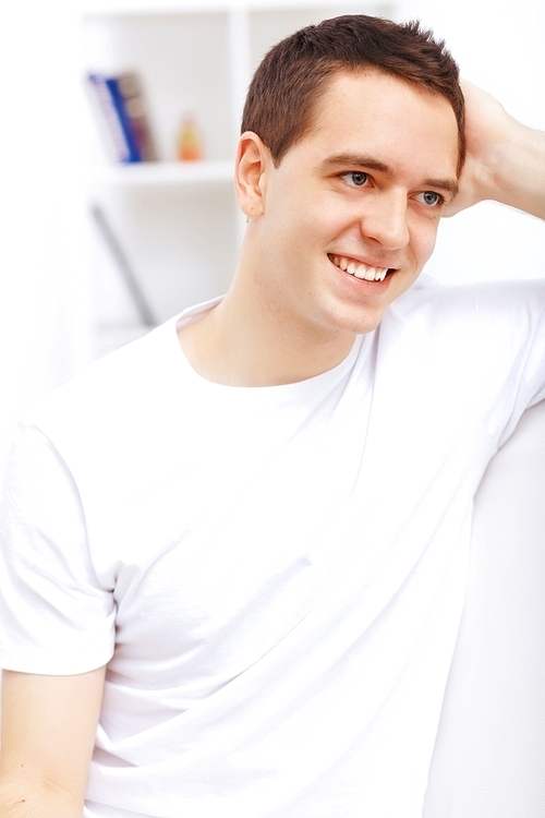 Young handsome man at home with a book