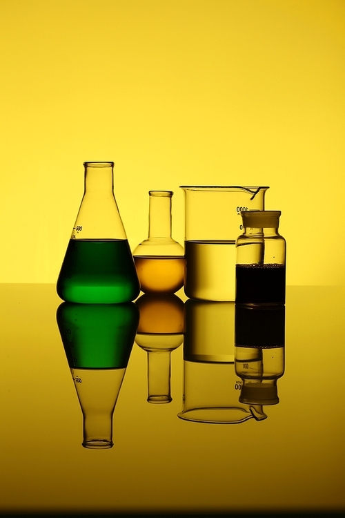 Glass chemistry tubes on a colour background