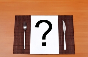 Metal knife and fork on the table and question mark