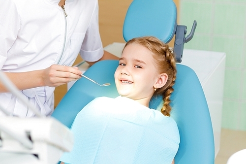 Little girl sitting in the dentists office