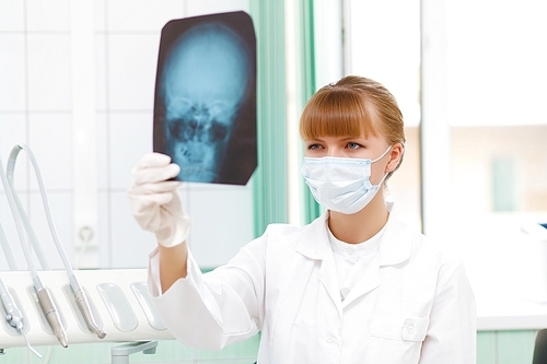 Young female doctor holding a X-ray sheet