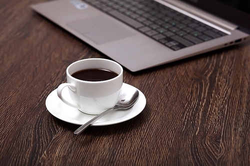 White cup with black coffee at business workplace