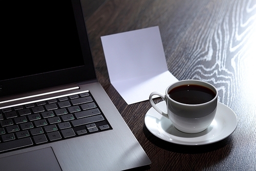 White cup with black coffee at business workplace