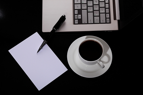 White cup with black coffee at business workplace